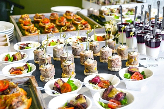 Guests serving themselves from baby shower brunch buffet in decorated dining space