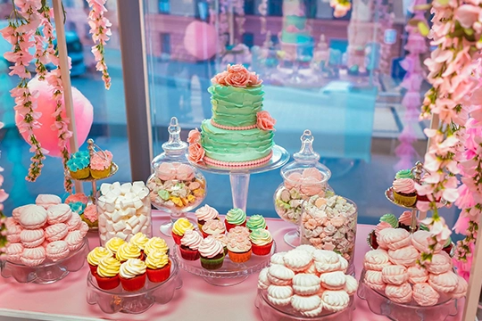 Children gathered around birthday cake while adult serves slices on plates
