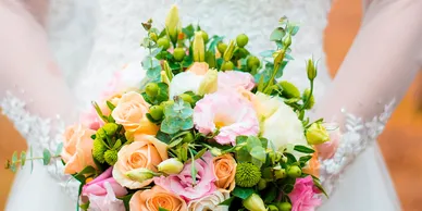 Rental vendor arranging white folding chairs in rows for outdoor ceremony